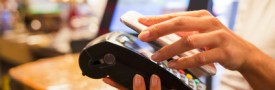 Woman paying with NFC technology on mobile phone, restaurant, ca