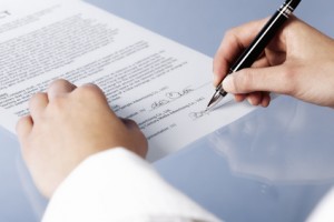 Macro of businesswoman signing contract.