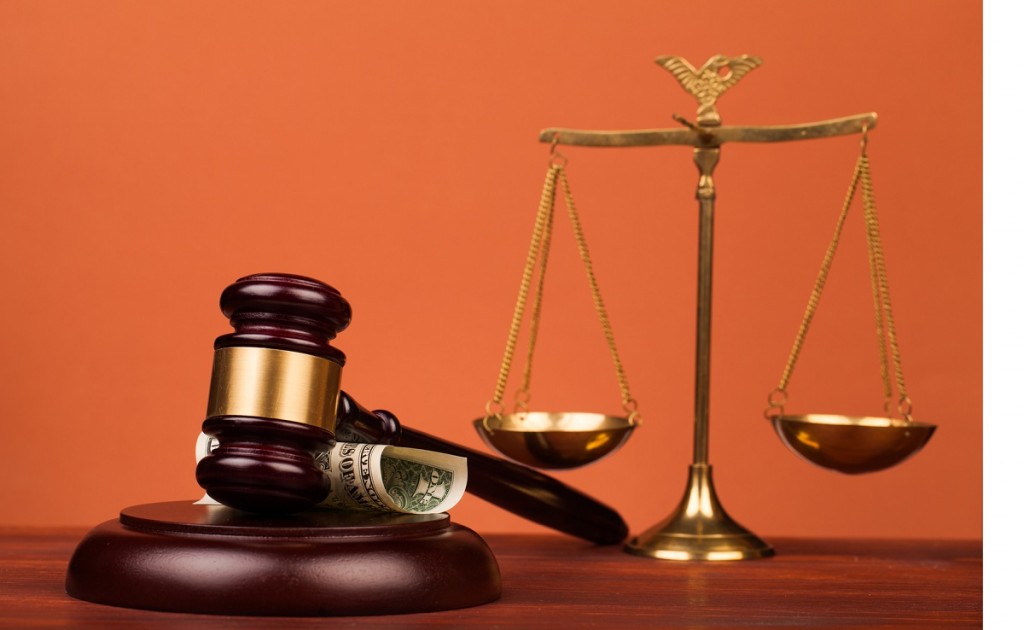 judge gavel,dollar money and scales of justice on table